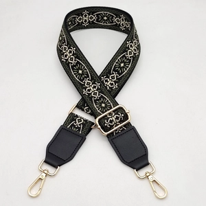 Detail of adjustable wide bag strap with ethnic woven pattern and gold lobster clasps