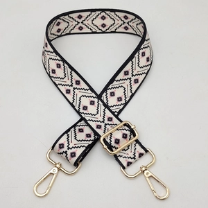 Detail of 3.8cm wide woven bag strap with geometric patterns and gold lobster clasps