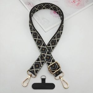Detail of bohemian geometric rhombic woven phone strap with gold adjustable buckle
