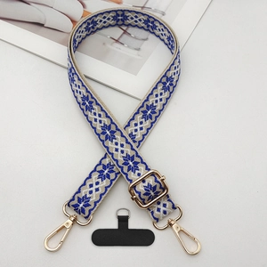 Detailed view of jacquard weave phone strap with blue patterns and gold metal hardware