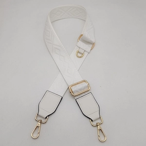 Détail de la bandoulière réglable blanche avec crochets dorés et tissage géométrique