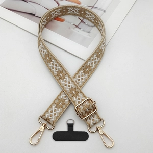Close-up of jacquard woven phone strap with geometric pattern and gold metal buckles