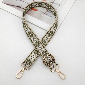 Close-up of green and white geometric ethnic embroidery on adjustable handbag strap