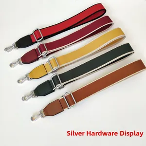Detail of silver metal lobster clasps and buckles on five colorful nylon bag straps