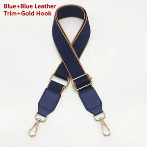 Detail of adjustable blue crossbody strap with gold metal hooks and tan leather accents
