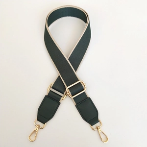 Detail of green and beige canvas bag strap with golden metal swivel lobster clasps