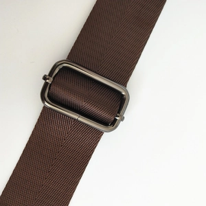 Macro shot of brown nylon strap texture and dark metallic rectangular adjustment buckle