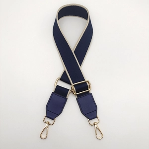 Close-up of ethnic style navy nylon bag strap with gold metal buckle and leather ends