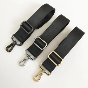 Detail of black nylon straps with metal hooks in gunmetal, silver, and gold finishes