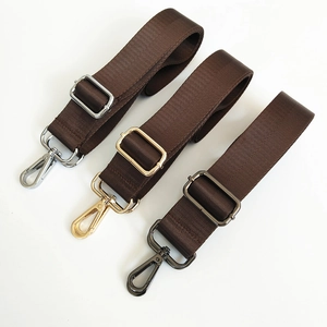 Detail view of dark brown nylon strap showing twill texture and three metallic hook colors