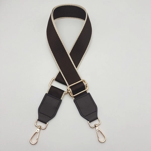 Adjustable canvas shoulder strap with brown fabric, beige edges and gold hardware