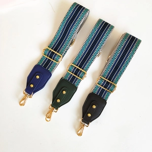Close-up of three ethnic geometric striped woven bag straps with gold metal hardware