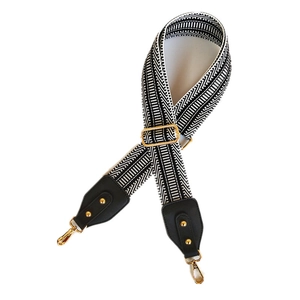Adjustable wide embroidered shoulder strap with black white geometric pattern and gold hooks