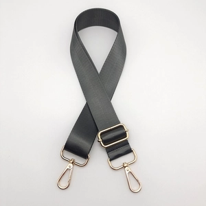 Detail of adjustable dark gray nylon shoulder strap with premium gold metal hardware