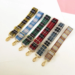 Detail of adjustable plaid bag straps in various colors with golden metal hardware