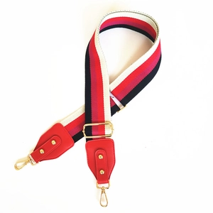 Adjustable wide striped shoulder strap with red leather ends and gold metal hooks