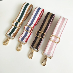 Detail view of four adjustable striped bag straps with gold hardware and lobster clasps