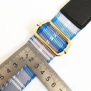 Close-up of blue and white geometric bag strap with golden metal adjustable buckle