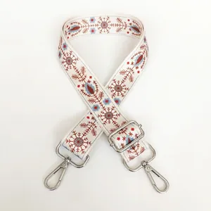 Detailed embroidery on wide adjustable bag strap with vintage floral patterns and silver hooks