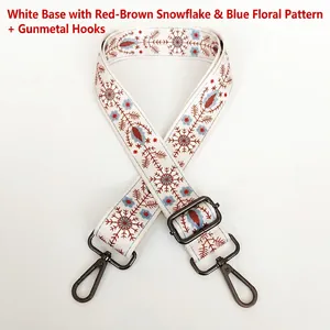 Detail of adjustable embroidered strap with floral patterns and gunmetal swivel hooks