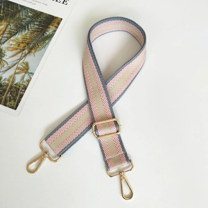 Detail of colorful striped woven bag strap with adjustable gold-tone metal hardware