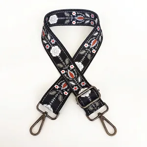Detail of floral embroidery on black guitar strap with gunmetal swivel lobster clasps