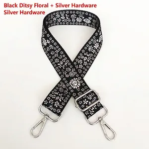 Detail of adjustable black floral bag strap with silver metal buckles and lobster clasps