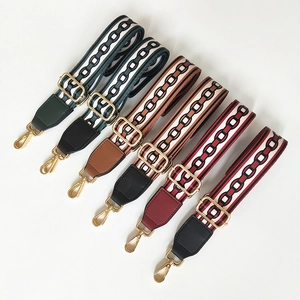 Detail view of six adjustable wide bag straps with geometric patterns and gold buckles