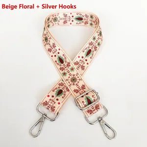 Close-up of embroidered wide bag strap with floral pattern and silver swivel hooks