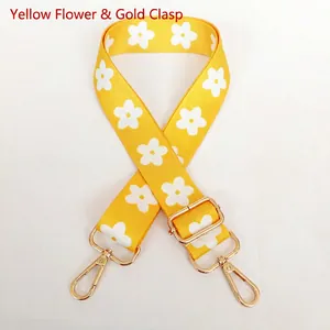 Detail of yellow floral strap with white daisy pattern and gold adjustable metal hooks