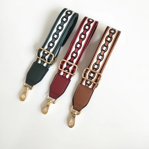 Macro detail of adjustable woven shoulder straps with geometric patterns and gold clips