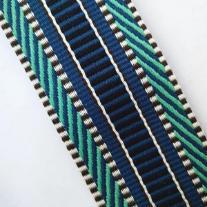 Detailed close-up of the geometric woven embroidery on the wide shoulder strap accessory