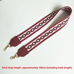 Detail of 100cm wide burgundy woven shoulder strap with geometric pattern and gold clips