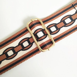 Close-up of adjustable golden metal buckle on a retro ethnic pattern bag strap