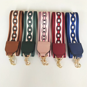Detail of five colorful nylon bag straps featuring geometric chain patterns and gold buckles