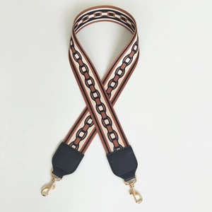Detail of wide nylon bag strap with vintage geometric pattern and gold swivel hooks