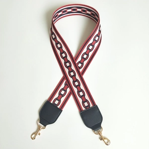 Detail of red and black chain-pattern woven strap with golden metal swivel lobster clasps