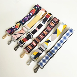 Detail view of ethnic style woven bag straps with geometric patterns and metal hooks