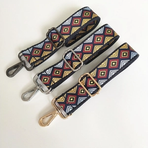 Detail of colorful geometric woven bag straps with gold, silver and black metal buckles
