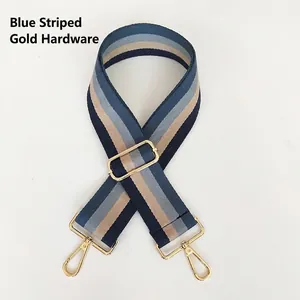 Adjustable striped canvas shoulder strap with blue tones and gold metal hooks