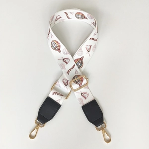 Detail of adjustable wide bag strap featuring colorful hot air balloon prints and gold hooks