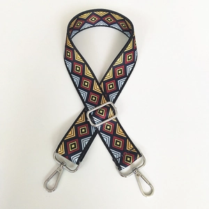 Detail of adjustable canvas strap with colorful ethnic diamond pattern and silver metal hooks