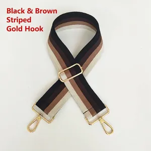 Close-up of adjustable striped canvas bag strap with gold metal hooks and buckle