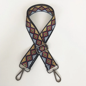 Detail of adjustable wide canvas shoulder strap with colorful ethnic geometric patterns
