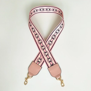Detail of pink and black woven wide strap with gold metal hooks for women's handbag