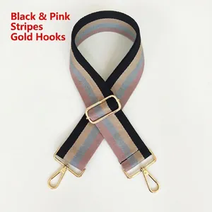 Detail of adjustable black and pink striped wide canvas strap with gold metal hooks