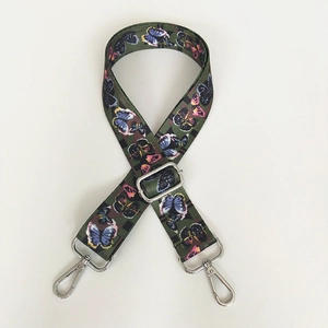 Detailed view of adjustable wide canvas bag strap with colorful butterfly patterns