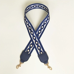 Close-up of wide nylon replacement strap with navy chain pattern and gold metal hooks