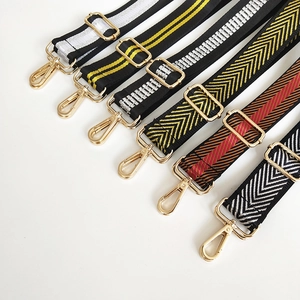Detail of adjustable wide bag straps with gold hardware and various woven patterns