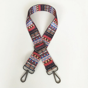 Close-up of ethnic geometric pattern bag strap with adjustable dark gray metal hooks